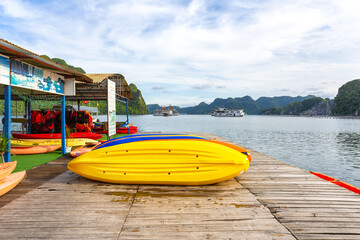 Tourists kayaking and paddling on the water amidst the towering karsts of Ha Long Bay