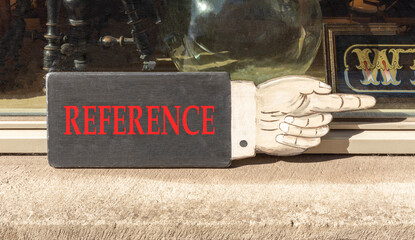 References or reference symbol. Concept word Reference on beautiful black wooden sign as a hand. Beautiful store front background. Business references or reference concept. Copy space.