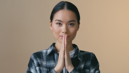 Asian Korean woman greeting namaste gesture folding hands calm face bowing praying ethnic female...