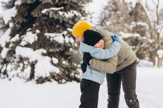 Father and son hugging in winter, celebrating family love, joy, and bonding outdoors in snowy nature