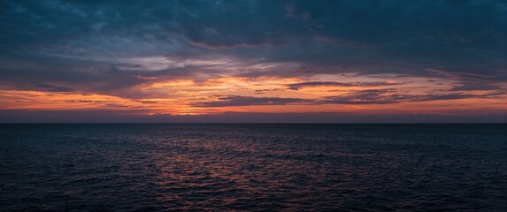 Serene seascape featuring a dramatic sunset sky and tranquil ocean