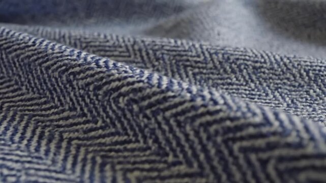 Elegant macro shot of premium soft textile featuring classic blue and white herringbone weave pattern with artistic draping folds and intricate woven texture detail for high-quality background.