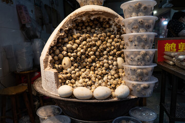 Authentic street cooking of quail eggs in traditional stove, local travel food experience and cultural cuisine concept