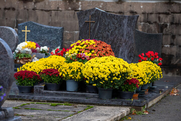 Gros bouquets de fleurs fraiches et multicolore déposés sur les tombes dans cimetière à...