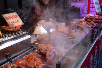 Asian street food roasted ducks hanging at market stall, traditional duck cooking, travel and local culture concept