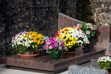 Gros bouquets de fleurs fraiches et multicolore déposés sur les tombes dans cimetière à...
