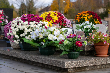 Gros bouquets de fleurs fraiches et multicolore d&eacute;pos&eacute;s sur les tombes dans cimeti&egrave;re &agrave; l'occasion de la Toussaint. France. Cela rend hommage au d&eacute;funt et t&eacute;moigne de l'attachement et du respect.
