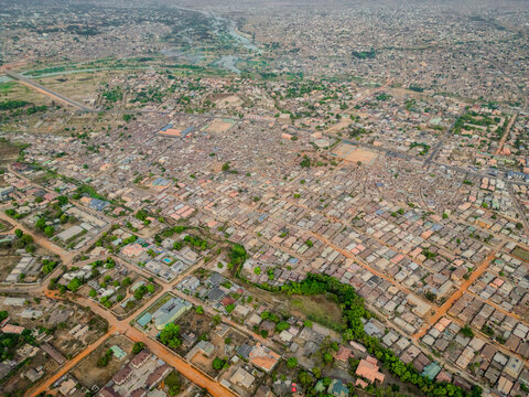 Aerial view of densely packed buildings interspersed with patches of green, creating a textured tapestry under a hazy sky, Kaduna, Kaduna, Nigeria.