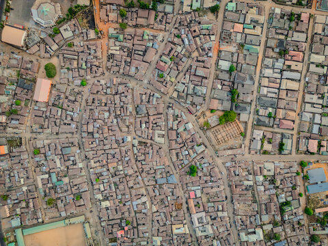 Aerial view of densely packed buildings create a textured tapestry, punctuated by the occasional splash of green, reflecting the vibrant urban life below, Kaduna, Kaduna, Nigeria.
