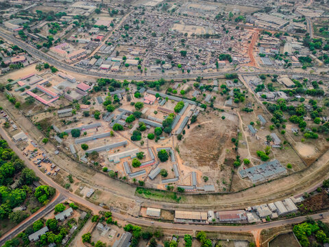 Aerial view of buildings with varied roof types amongst the trees, set against a backdrop of urban sprawl, Kaduna, Kaduna, Nigeria.