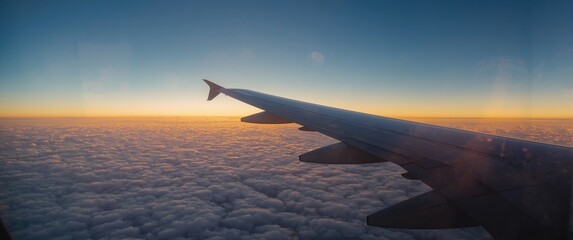 Obraz premium Passenger perspective of the sky and Earth beyond the airplane window with wing in sight