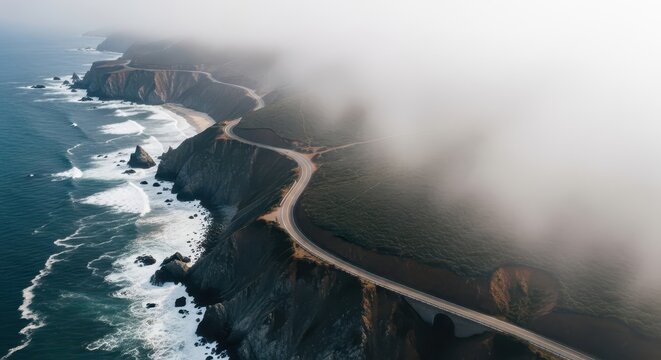 Elevated view captures winding coastal highway disappearing into thick atmospheric fog