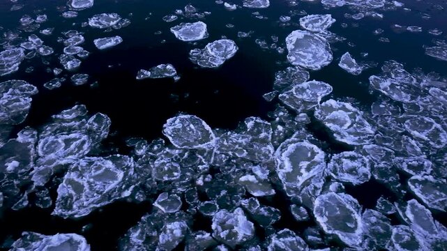 Aerial Vistula River winter icebergs night Poland. Winter season cold arctic temperatures form ice flows dangerous ice jams block and damage waterway. Beautiful shore with ice bergs floating.