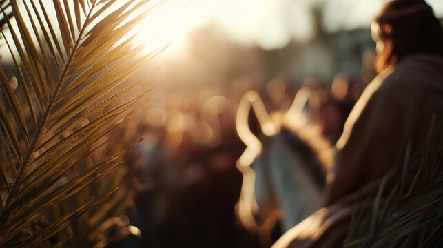 Close up palm branch in foreground with jesus riding a donkey blurred in background during palm sunday procession at sunset for holy week religious use.