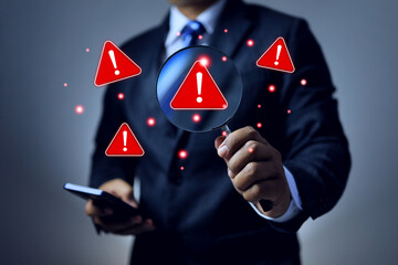 threat detection and risk management concept with businessman using magnifying glass to search on alert sign represents cyber security or scam protection