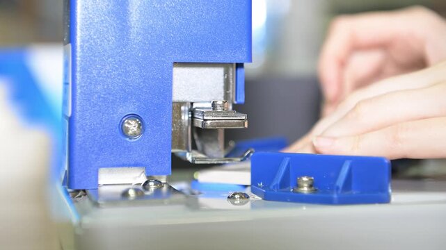 The process of cutting corners of printed products with a mechanical machine in the production room of the printing house