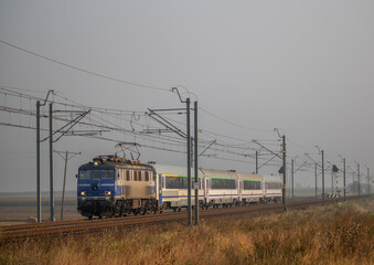 Stara lokomotywa z pociągiem intercity podąża wczesnym rankiem po zmodernizowanej linii kolejowej © Erap2