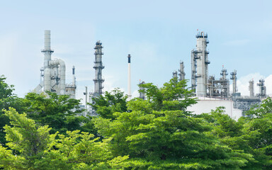 Obraz premium Oil refinery plant from industry zone with lush green trees, large Oil and gas petrochemical industrial, Refinery factory oil storage tank and pipeline, Ecosystem and good environment concept. 