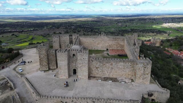 A 4K aerial drone video filmed in the historic town of Trujillo, Extremadura, Spain. The drone flies slowly forward at altitude toward the medieval Trujillo Castle, a filming location of Game of
