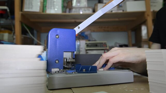 The process of cutting corners of printed products with a mechanical machine in the production room of the printing house