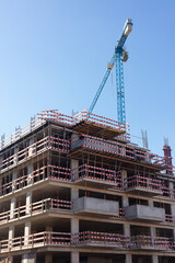 Naklejka premium Building under construction with tower crane and safety barriers