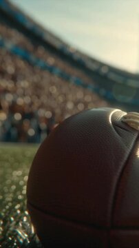 close-up slow-motion video. A brown ball is fixed by an American football player in order to be kicked forward into the stadium