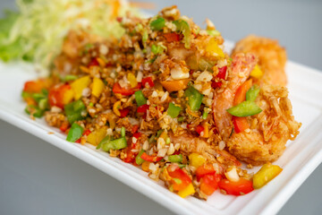 Stir fried shrimp with salt and chili, served on plate with vegetable