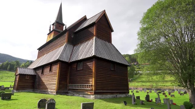 Cinematic view of Kaupanger Stave Church in Norway, with ancient tombstones in the foreground with no one. A peaceful, historic Viking landscape with no people