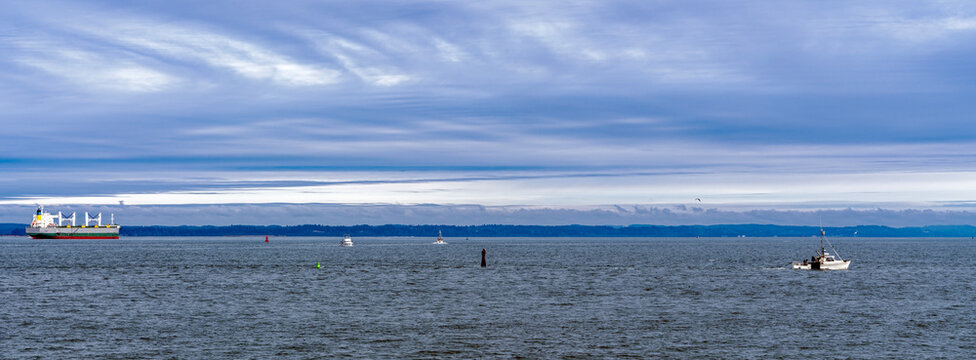 Panorama of a bulk carrier moored off Westhaven Cove with fishing trawlers at Westport, Washington, USA