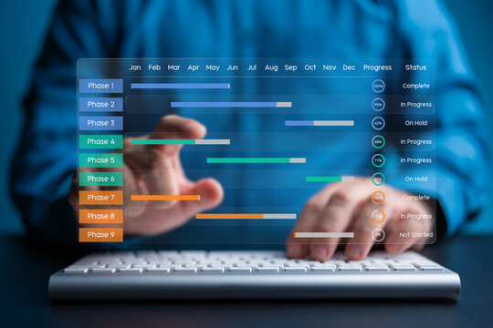 Person using a keyboard to update a virtual glass effect Gantt chart showing project phases and progress. Focus on operational efficiency, scheduling, and professional project management technology.