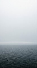 Obraz premium Heavy mist obscures the horizon over the vast ocean water, creating a mysterious and serene natural environment ,deep ,abstract ,blur