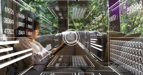 Holding tablet, Chinese girl wearing glasses and hoodie leaning on sofa at home, viewing AR panels