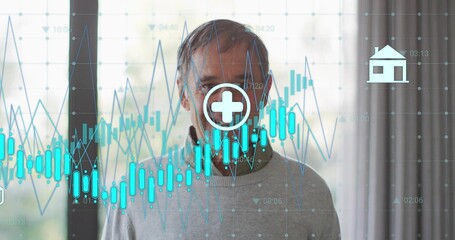Standing senior in gray sweater, collared shirt at home, showing charts, medical cross, house icon