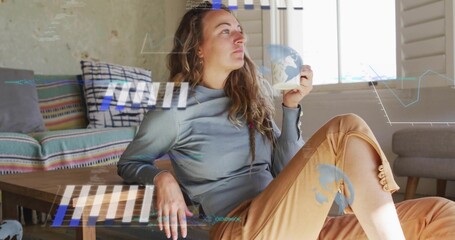Sipping woman in gray top, tan pants in living room holding white mug with AR overlays