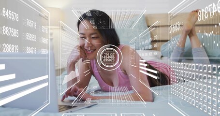 Propping elbows Korean woman wearing pink tank top, using open laptop on bed with AR graphics