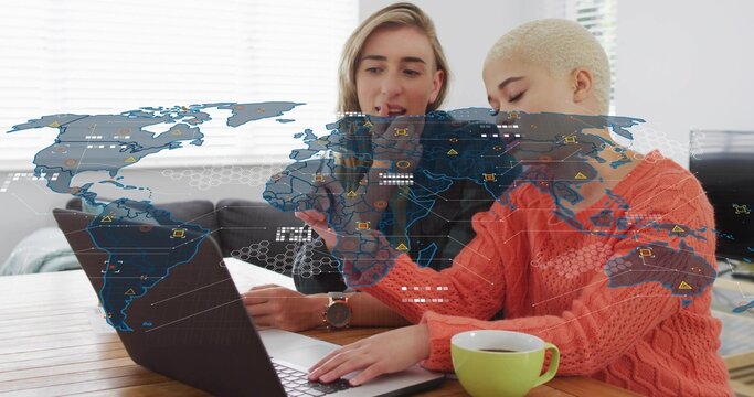 Working two women leaning over laptop in living room, wearing orange sweater, pointing at AR map - Powered by Adobe