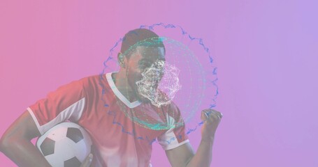 Holding soccer ball, male athlete in red soccer jersey pumping fist in studio with holographic mesh
