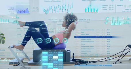 Performing woman executing core curl on reformer in studio, purple cushion, pink bra, data overlays