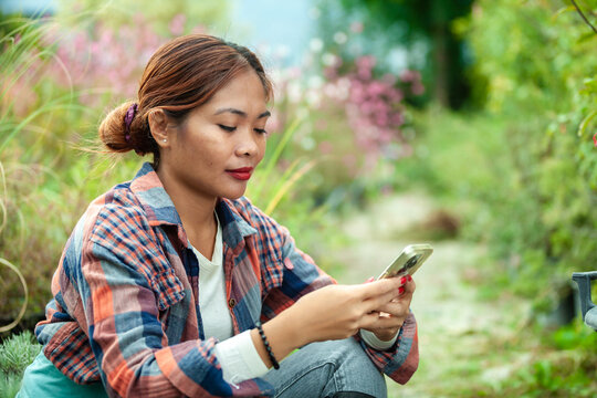 Woman using smart phone in a garden