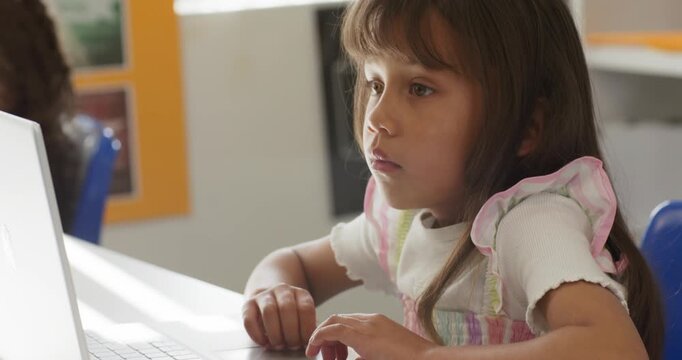 Classmates African American girl child using laptop  and  trackpad, doing classwork at desk, copy sp