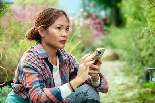 Woman using smart phone in a garden