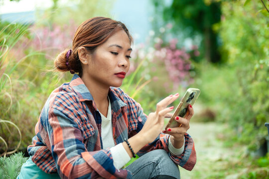 Woman using smart phone in a garden
