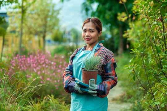 Woman gardening with potted plant in vibrant garden
