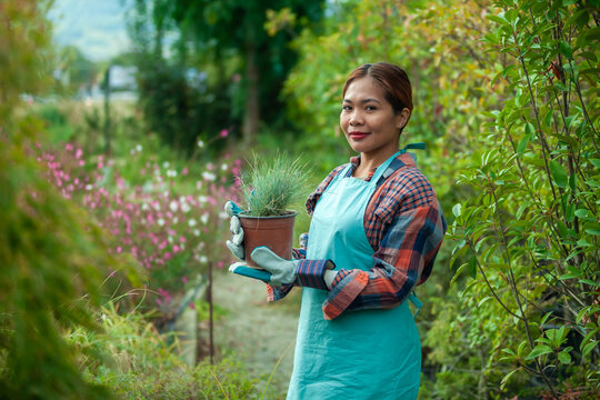 Woman gardening with potted plant in vibrant garden