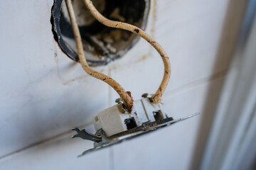 Close-up of old-fashioned cloth insulated electrical wiring in a wall socket. Perfect for showing...