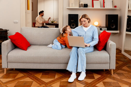 Working mother multi tasking, managing remote work and family life at home