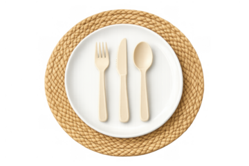 Compostable cutlery set with fork, knife, spoon on white plate and woven placemat top view, transparent background