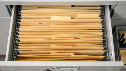 Drawer containing organized folders in an office setting with documents categorized for easy access and retrieval at any time