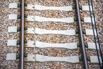 Close-up of a section of a railway track with wooden sleepers and cast-iron rails covered with gravel. Cause of disaster, Spain, accident