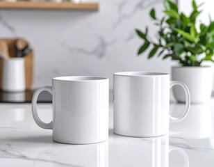 Obraz premium Two pristine white coffee mugs sit on a marble countertop in a bright kitchen. A leafy plant and wooden items are in the background